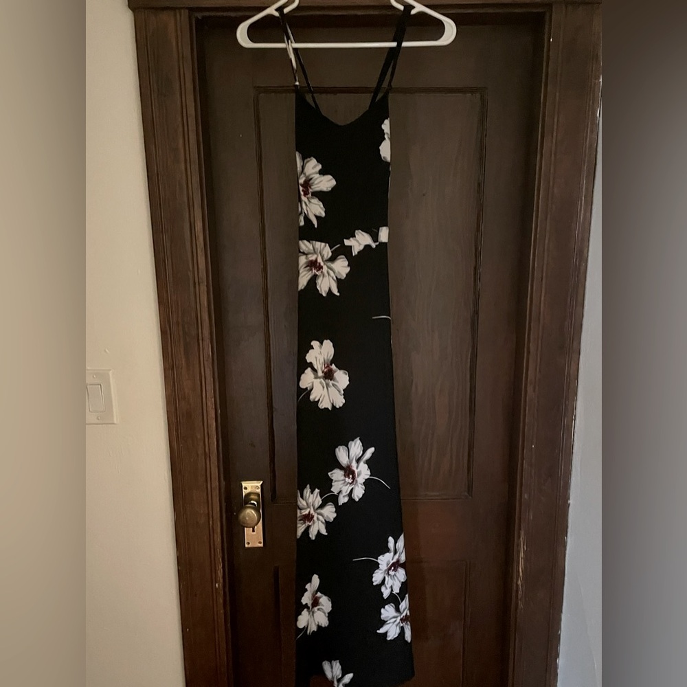 Black a-line maxi dress with flower detail and open cross cross back.